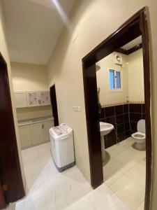 ein Badezimmer mit einem WC und einem Mülleimer in der Unterkunft شقق لمسات in Al-'Ula