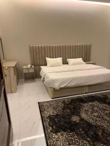 ein Schlafzimmer mit einem Bett und einem Teppich in der Unterkunft شقق نور سين in Al-'Ula