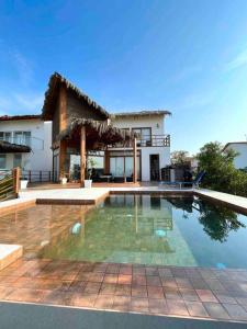 a house with a swimming pool in front of a house at NAUTICA CHINCHA Casa con Piscina frente al mar in Casa Blanca