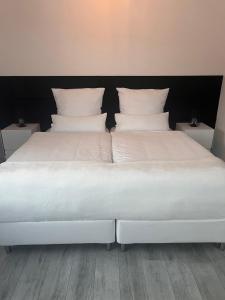 Una gran cama blanca con almohadas blancas. en Haus am Waldrand en Bad Hersfeld