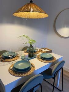 una mesa con platos y sillas azules y una luz en Apartamento en Santander con vistas al mar, en Santander
