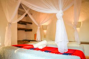 a bedroom with a canopy bed with white curtains at Hotel El Cogollo By MH in Barichara