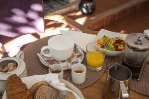 a table with a breakfast of bread and coffee and juice at Chambres D'hôtes Amarilli in Toulouse