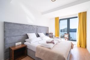 une chambre avec un grand lit et une grande fenêtre dans l'établissement Apartment Laurus five stars, à Dubrovnik