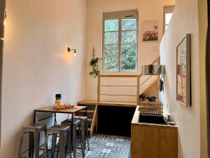 - une petite cuisine avec une table et quelques tabourets dans l'établissement Suite Coraline, à Lyon