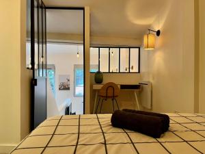 a bedroom with a bed and a desk in it at Suite Coraline in Lyon