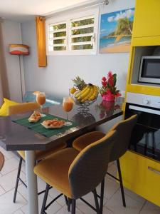 einen Esstisch mit 2 Gläsern Orangensaft in der Unterkunft Le Cocon de l'Oranger in Le Moule