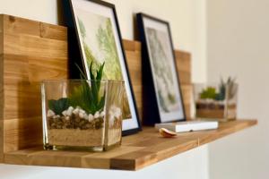een houten plank met een glazen vaas en planten erop bij Quiet luxury nest in the heart of Gérardmer in Gérardmer