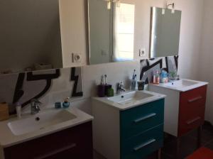 a bathroom with two sinks and a mirror at Plages débarquements .DDay. Près de Caen in Verson