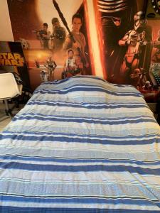 a blue and white striped bed in a bedroom at Plages débarquements .DDay. Près de Caen in Verson