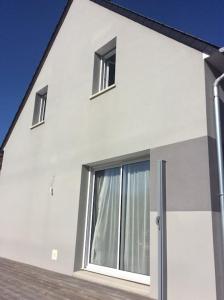 une maison blanche avec deux fenêtres et une porte dans l'établissement Plages débarquements .DDay. Près de Caen, à Verson