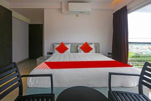 a bedroom with a large bed with red pillows at Botcha Convection in Visakhapatnam