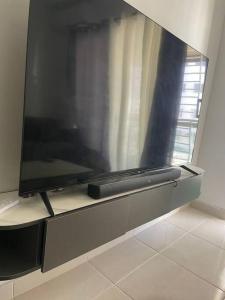 telewizor z płaskim ekranem siedzący na półce w obiekcie Tranquilo apartamento cercano al aeropuerto w mieście Los Paredones