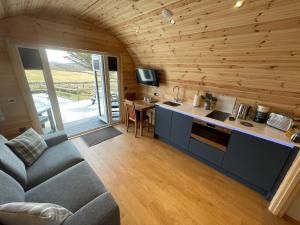 a kitchen and living room with a couch and a table at Stoer Pods - Suilven Pod in Lochinver