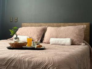 a bed with a tray of food and drinks on it at Hotel Vitali in Concepción