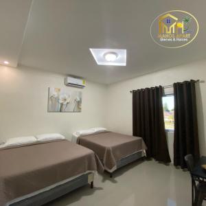 um quarto de hospital com duas camas e uma janela em Maho's Apartamentos em Tela