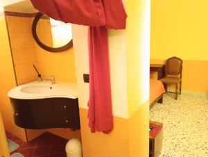 uma casa de banho com um lavatório e um espelho em B&B I tre gatti em Frassinello Olivola
