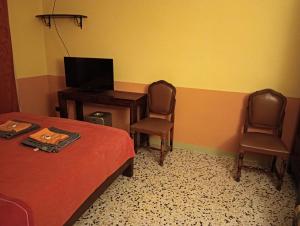 1 dormitorio con 1 cama, escritorio y 2 sillas en B&B I tre gatti, en Frassinello Olivola