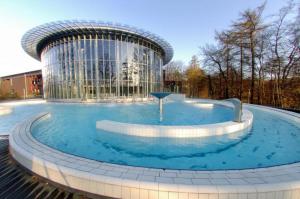 a large pool of water in front of a building at L'impossible in Spa