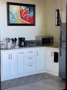 a kitchen with white cabinets and a microwave at Villa Del Mar 1 Spectacular ocean view! in Dominical