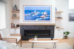 a living room with a picture of people swimming in the water at The Harbor Lookout in Newport Beach