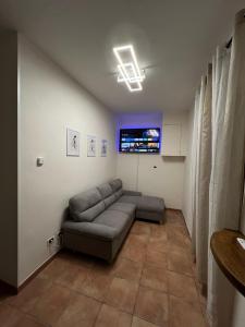 a living room with a couch and a tv at Appartamento vicino al centro di Tortona in Tortona