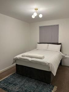 a bedroom with a large bed with white sheets at Cosy 2 Bedroom Apartment with Parking by Cloud Suites in Manchester