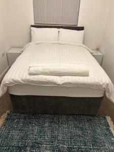 a bed in a bedroom with a white comforter at Cosy 2 Bedroom Apartment with Parking by Cloud Suites in Manchester