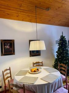 een eetkamer met een tafel met een kerstboom bij Attico con vista sulle Tofane in Maion