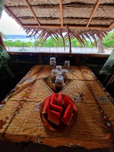 une table avec une plaque de pastèque au-dessus dans l'établissement Mahana Tua Lodge Huahine, à Puahua