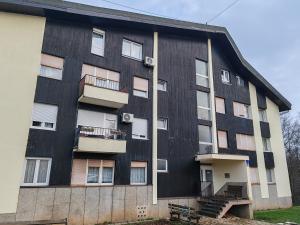 a black building with balconies on the side of it at Apartman Orchid in Plitvička Jezera