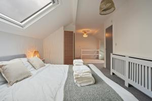 a bedroom with a large bed with white sheets and pillows at Luxury Sheffield Apartment - Your Ideal Home Away From Home in Stannington