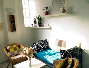 ein Wohnzimmer mit einem blauen Sofa und Stühlen in der Unterkunft Appartement cosy près de Paris. in Livry-Gargan