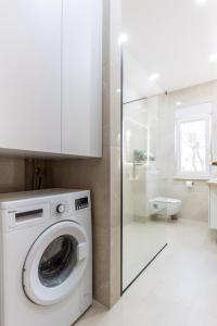 uma máquina de lavar roupa branca na casa de banho com um chuveiro em Apartment Blue em Stobreč