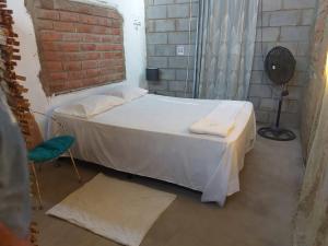 a bedroom with a bed and a brick wall at Hostal Brisas del Ometepe in Rivas