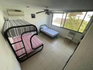 a room with two bunk beds and a bench at Depa Roca Sola Acapulco Costera in Acapulco