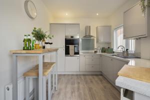 Luxury Sheffield Apartment - Your Ideal Home Away From Home في Stannington: مطبخ بدولاب بيضاء وقمة كونتر