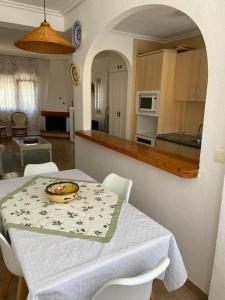 a kitchen with a table with a bowl of fruit on it at Punta Prima Gataway in Torrevieja