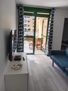 ein Wohnzimmer mit Couch und Fernseher in der Unterkunft Las Olas Blue in Playa del Ingles