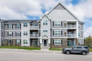 a large house with a car parked in front of it at Modern Luxury Apartment near GRR Airport and Mall in Kentwood