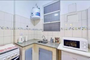 a white kitchen with a sink and a microwave at En el corazón de la ciudad! in Buenos Aires