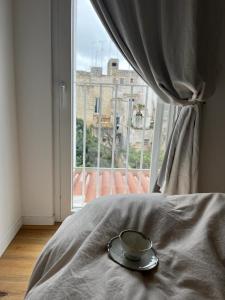 a cup on a bed in front of a window at Casa Guido Eco Friendly in Lecce