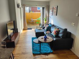 een woonkamer met een zwarte bank en een tafel bij Modern Central Brighton patio flat - free parking! in Brighton & Hove