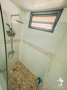 a bathroom with a shower and a window at Airport Pamatai Studio in Faaa