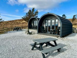 a picnic table and bench in front of a building at Stoer Pods - Quinag Pod in Lochinver