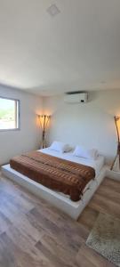 a large bed in a white room with two lamps at Casa Piscis Spa in Taganga +30 photos