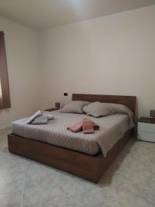 a large bed in a bedroom with two towels on it at Casa Adele in San Sperate