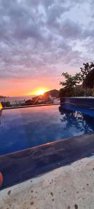 a sunset over the ocean with a swimming pool at Casa Piscis Spa in Taganga