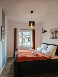 a bedroom with a large bed with a window at Design-Apartment I Black Forest I Boxspring I Nespresso I Spielplatz in Oberharmersbach