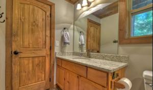 un baño con lavabo y espejo en Chalet Blue Ridge, en Blue Ridge 26 fotos más